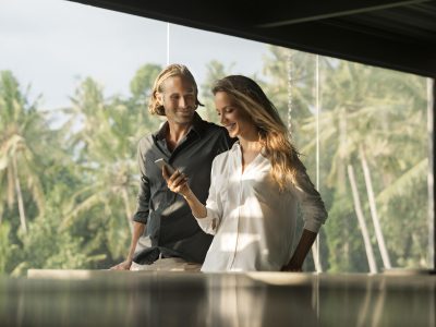 smiling-couple-with-smartphone-in-design-house-2024-09-23-03-12-13-utc-min